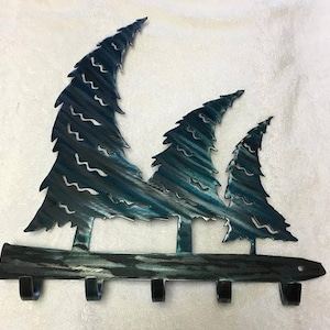 May include: Metal key rack with five hooks shaped like a row of pine trees with a blue and green paint finish.