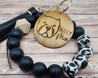 May include: Black and white beaded keychain with a wooden charm featuring a bulldog silhouette and the text "Bully Mom".