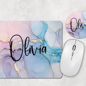 May include: A mouse pad with a blue, pink, and gold marble design. The name "Olivia" is written in black cursive on the mouse pad. A matching round coaster with the same design and name is also included.