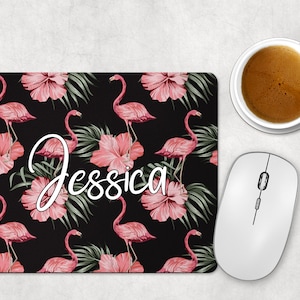 May include: A black mouse mat with a pink flamingo pattern and green leaves. The name "Jessica" is written in white cursive on the mouse mat.