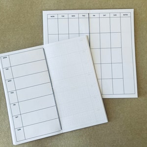 Può includere: Due quaderni bianchi aperti con linee di griglia nere. Il quaderno a sinistra ha i giorni della settimana etichettati: Lun, Mar, Mer, Gio, Ven, Sab, Dom. Il quaderno a destra ha i giorni della settimana etichettati: Lun, Mar, Mer, Gio, Ven, Sab, Dom, e una colonna etichettata Note.