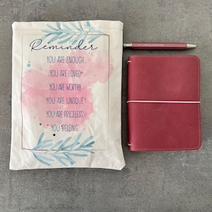 Midori traveler&#39;s notebook in real leather currant color a6 format complete with coordinated book sleeve.