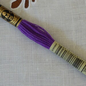 Op de afbeelding: Paarse DMC borduurgaren met een gouden label met de tekst "DMC Special 25m (8.7 yd) 3837".