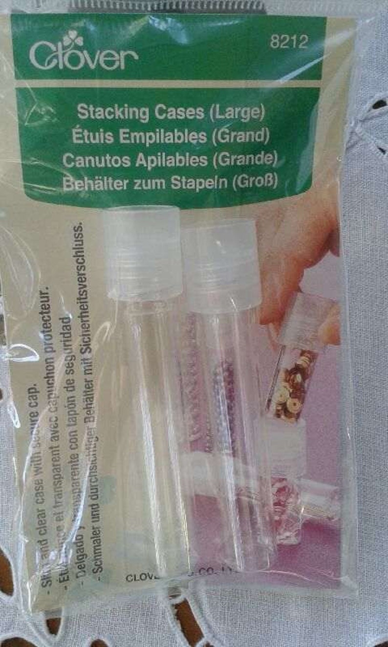 May include: Two clear plastic stacking cases with lids, labeled "Stacking Cases (Large)", "&Eacute;tuis Empilables (Grand)", "Canutos Apilables (Grande)", and "Beh&auml;lter zum Stapeln (Gro&szlig;)".