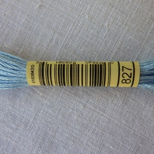 Op de afbeelding: Een klosje lichtblauwe borduurgaren met een geel label waarop "827" staat. Het label heeft ook een barcode en het nummer "5103042Q".