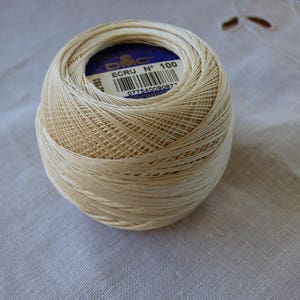 May include: A ball of off-white embroidery floss with a blue and white label that reads "DMC ECRU N° 100 0775400090877".