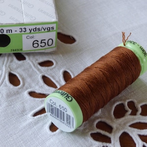 May include: A spool of brown Gütermann thread with a green label that reads "Col. 650" and "30 m - 33 yds/vgs".