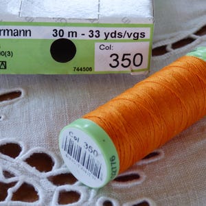May include: A spool of orange Gütermann thread with a green label that says "Col 350" and "2776". The spool is 30 metres or 33 yards long.