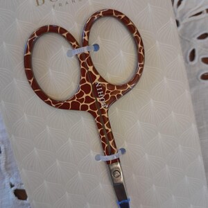 Peut inclure: Une paire de petites ciseaux pointues avec un motif imprimé de girafe. Les ciseaux sont fabriqués par Bohin France et sont étiquetés "Ciseaux Fantaisie".