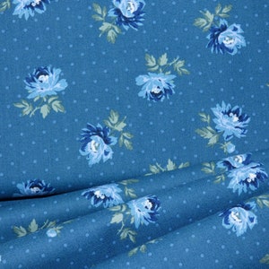 Peut inclure: Tissu bleu avec un motif de pois blancs et un imprimé floral de fleurs bleues.