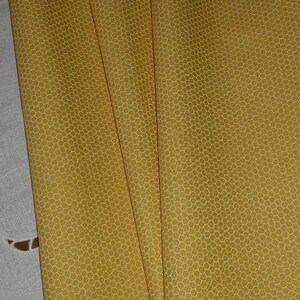 Peut inclure: Quatre morceaux de tissu jaune avec un motif en nid d'abeille blanc.