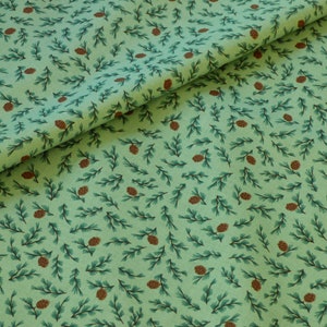 Könnte beinhalten: Grüner Stoff mit einem sich wiederholenden Muster aus braunen Tannenzapfen und grünen Tannenzweigen.