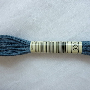 Op de afbeelding: Een klosje blauwe borduurgaren met een label met de tekst "DMC 930" en een barcode.