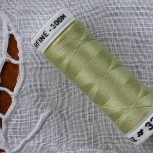 May include: A spool of light green thread labelled "R-FINE - 300M" and "# 328".