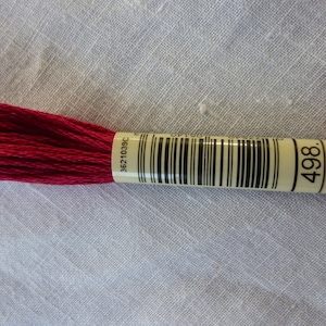 Op de afbeelding: Een spoel rode borduurgaren met een wit label waarop "498." en een barcode staan. Het label heeft ook het nummer "3621039C" erop gedrukt.