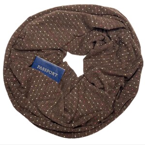 May include: A brown infinity scarf with a small blue pocket that says "PASSPORT" on it. The scarf has a subtle pattern of small, colorful dots.