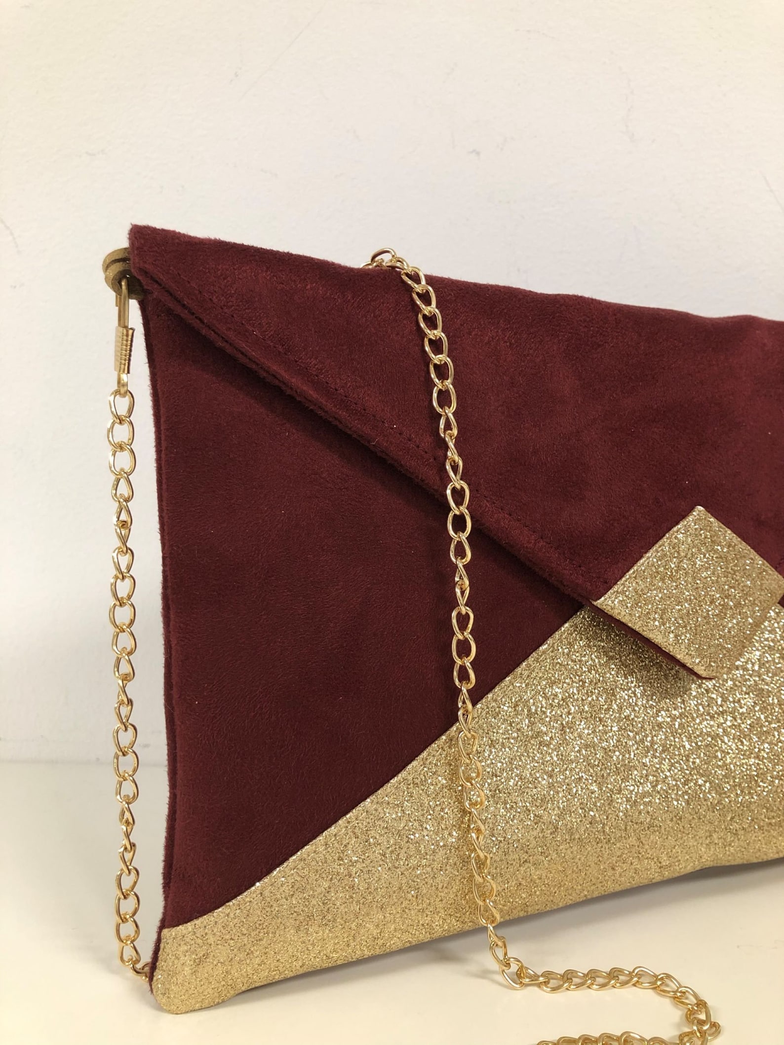 burgundy and gold clutch bag