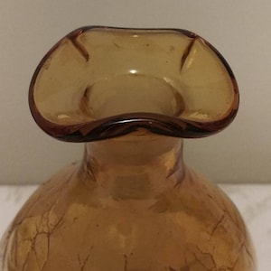 May include: Amber glass vase with a ruffled top and a textured surface.