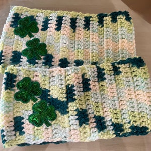 May include: Two crocheted green, white, and blue striped headbands with green shamrock embellishments.