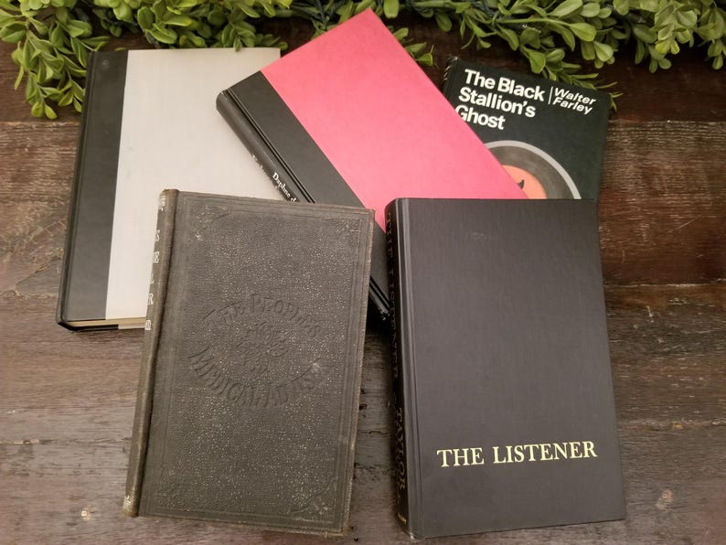 May include: A collection of five vintage hardcover books with black and white covers. The books are titled "The Black Stallion's Ghost" by Walter Farley, "The Listener", "The World's Medical Classics", and two other books with titles that are not visible.