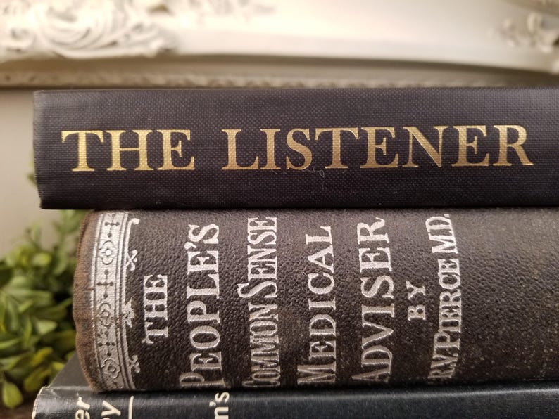 May include: A stack of three vintage hardcover books with black covers. The top book has gold lettering that reads "THE LISTENER". The second book has white lettering that reads "THE PEOPLE'S COMMON SENSE MEDICAL ADVISER BY R.V. PIERCE MD."