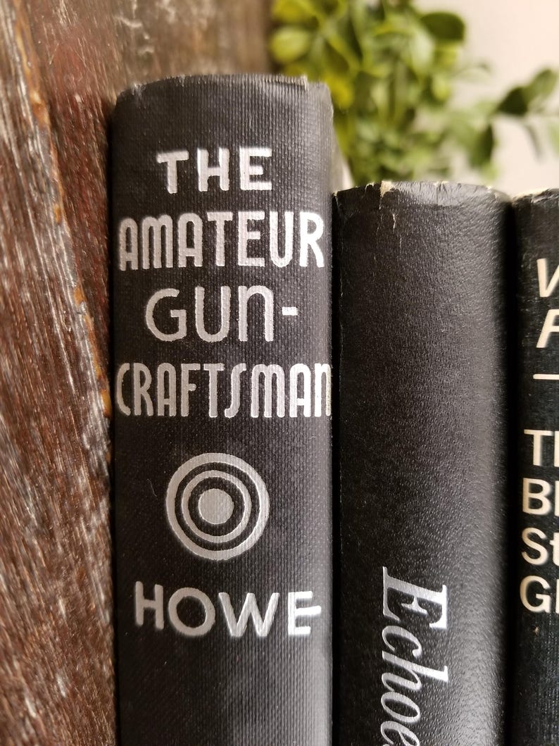 May include: Close-up of three black hardcover books with white text. The first book is titled "The Amateur Gun-Craftsman" with a silver circle logo and the author's name "HOWE". The second book is titled "Echoes" and the third book has the title "The Best Stories of G"