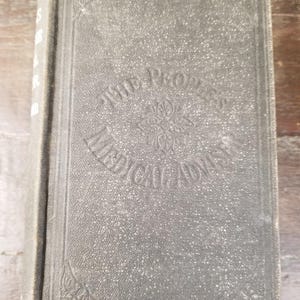 May include: A black hardcover book with the title "The Progress of Liberal Ideas" embossed on the front cover.
