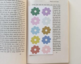 May include: A sheet of colorful flower stickers with a white background. The stickers are in various colors, including pink, blue, yellow, green, and brown. The stickers are in the shape of a flower with five petals.