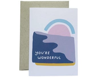 May include: A greeting card with a colorful abstract design of a sunset over a landscape. The card says "You're Wonderful" in white text.