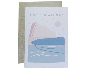 May include: A white card with a light blue and pink illustration of a mountain and a body of water. The text "Happy Birthday" is printed in black at the top of the card.
