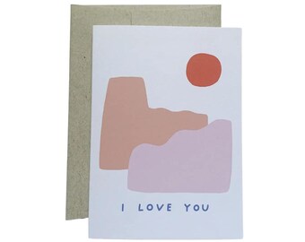 May include: A greeting card with a simple abstract design of pink and purple hills and a red sun. The text "I love you" is printed in blue at the bottom of the card.