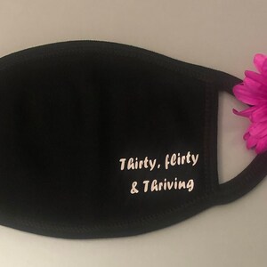 May include: Black face mask with white text that reads "Thirty, flirty & thriving".