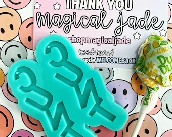 Può includere: Uno stampo in silicone blu turchese a forma della parola "GIRL" con un lecca-lecca e un biglietto di ringraziamento che dice "Grazie magical jade shopmagicaljade ne hai bisogno di più? Codice WELCOMEBACK" sullo sfondo.