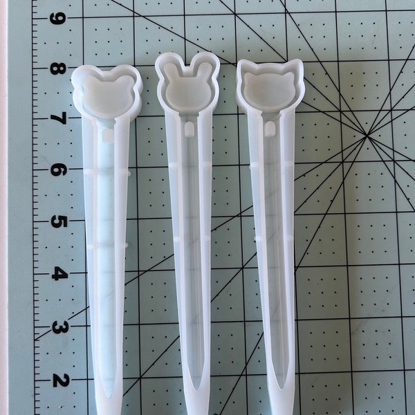 Peut inclure: Trois moules en silicone transparents pour la fabrication de stylos en résine. Les moules sont en forme de poussin, de lapin et de chat.
