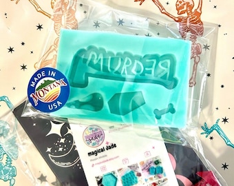 Puede incluir: Una bolsa de plástico transparente que contiene un molde de silicona turquesa con la palabra "MURDER" en una fuente de estilo graffiti. El molde también incluye un ataúd, un hueso y una calavera. La bolsa también contiene una tarjeta negra con un diseño de luna y estrellas, un pequeño paquete rojo y una tarjeta blanca con el texto "magical jade" e imágenes de varios moldes de silicona.