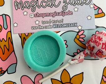 May include: A turquoise blue silicone mold with a circular design. The mold is sitting on a white surface with a colorful pattern. The text "THANK YOU magical jade" is visible on a pink and purple card behind the mold.