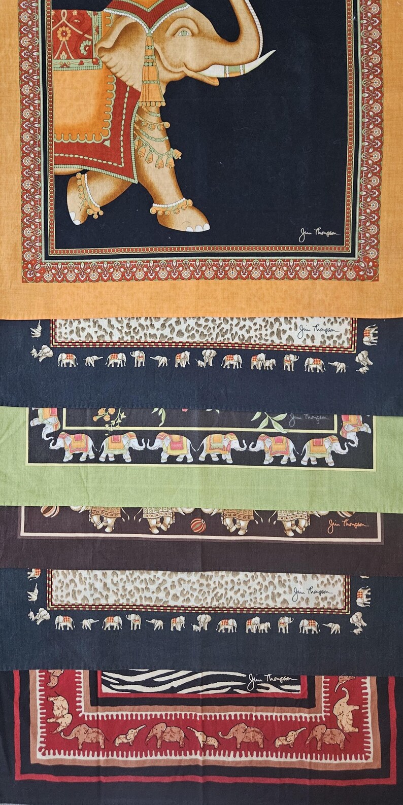 K&ouml;nnte beinhalten: Dekoratives Textil mit einem Elefantenmuster und detaillierten Mustern. Das Textil hat ein Patchwork-Design mit verschiedenen Paneelen, die Elefantenmotive, Leopardenmuster und florale Elemente zeigen. Die Farbpalette umfasst Orange, Schwarz, Gr&uuml;n und Braun.