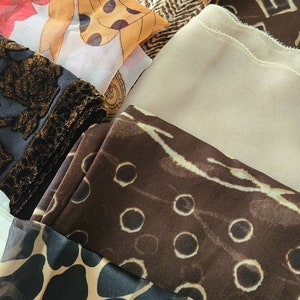 Op de afbeelding: Een verzameling stofstalen met verschillende dierenprintpatronen. De stalen omvatten luipaardprint, cheetahprint en een bruine stof met witte stippen.