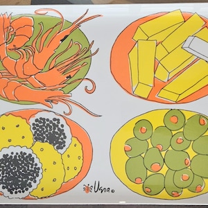May include: A rectangular white serving tray featuring four colorful illustrations of food. The top left shows orange shrimp on a green plate, top right shows yellow rectangular snacks on an orange plate, bottom left shows yellow and black circular snacks on an orange plate, and bottom right shows green olives on a yellow plate. The text "Vana" is printed near the bottom.