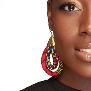 May include: A pair of red, blue, yellow, and black fabric dangle earrings with a gold metal top.