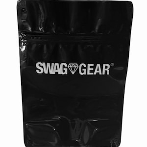 May include: Black stand-up pouch with a zipper closure. The pouch has a white logo that says "SWAG GEAR" with a diamond symbol.