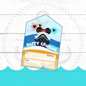 May include: A blue and yellow cruise ship gift tag with Mickey Mouse ears and fireworks. The tag says "Happy Cruising" and has spaces to write "To" and "From" and a stateroom number.
