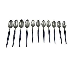 Puede incluir: Conjunto de diez cucharas de plata con mangos azules. Las cucharas están dispuestas en fila sobre un fondo blanco.