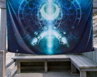 May include: A blue tapestry with a celestial design featuring two faces, a crescent moon, and astrological symbols. The artwork is displayed outdoors on a wooden structure, creating a mystical and artistic ambiance.