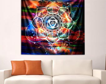 May include: A vibrant tapestry with a central mandala design, featuring a complex pattern of geometric shapes and a spectrum of colors including blue, red, orange, and green. The tapestry is hanging above a white sofa with two orange throw pillows.