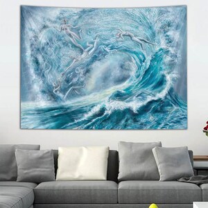 May include: A large tapestry depicting a dynamic ocean scene with a towering wave. Several figures are depicted within the wave, rendered in shades of blue and white. The artwork is mounted above a gray sectional sofa.