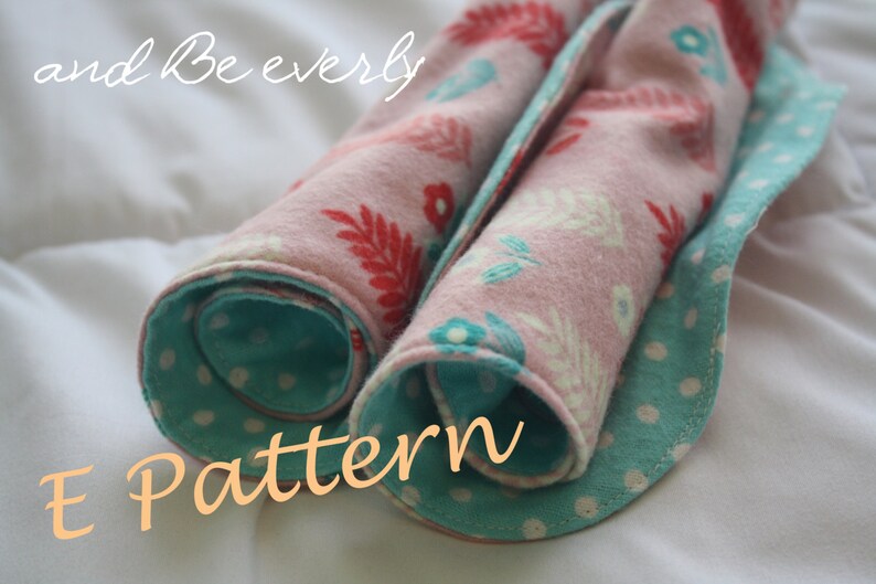 May include: Two rolled up fabric squares with a floral pattern on one side and a teal polka dot pattern on the other side. The fabric is pink with red and white floral designs. The teal fabric has white polka dots. The text "E Pattern" is written in orange on a white background.