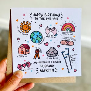 May include: A square white birthday card featuring colorful hand-drawn illustrations and text. The card reads: Happy Birthday to the one who is my ray of sunshine, is my best friend, makes my world a brighter place, is my happy place, is the best, is my rock, is my strength, my gorgeous and lovely husband Martin, and supports me when I need it.