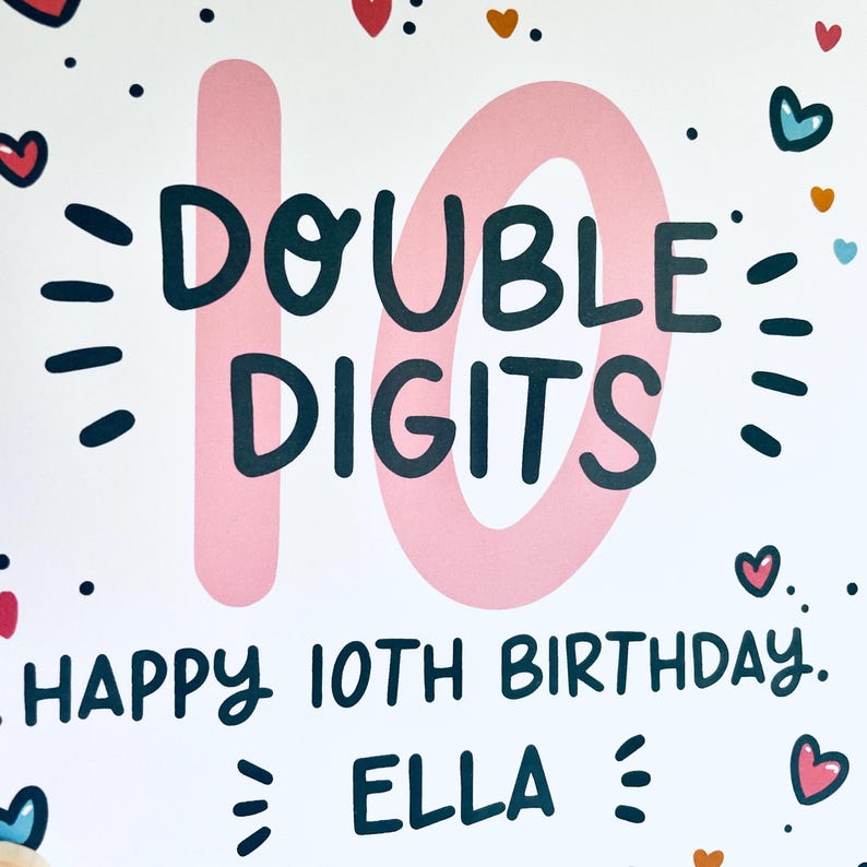 Op de afbeelding: Een roze en witte verjaardagskaart met de tekst "DOUBLE DIGITS" en "HAPPY 10TH BIRTHDAY. ELLA" in zwart. De kaart is versierd met hartjes en stippen.