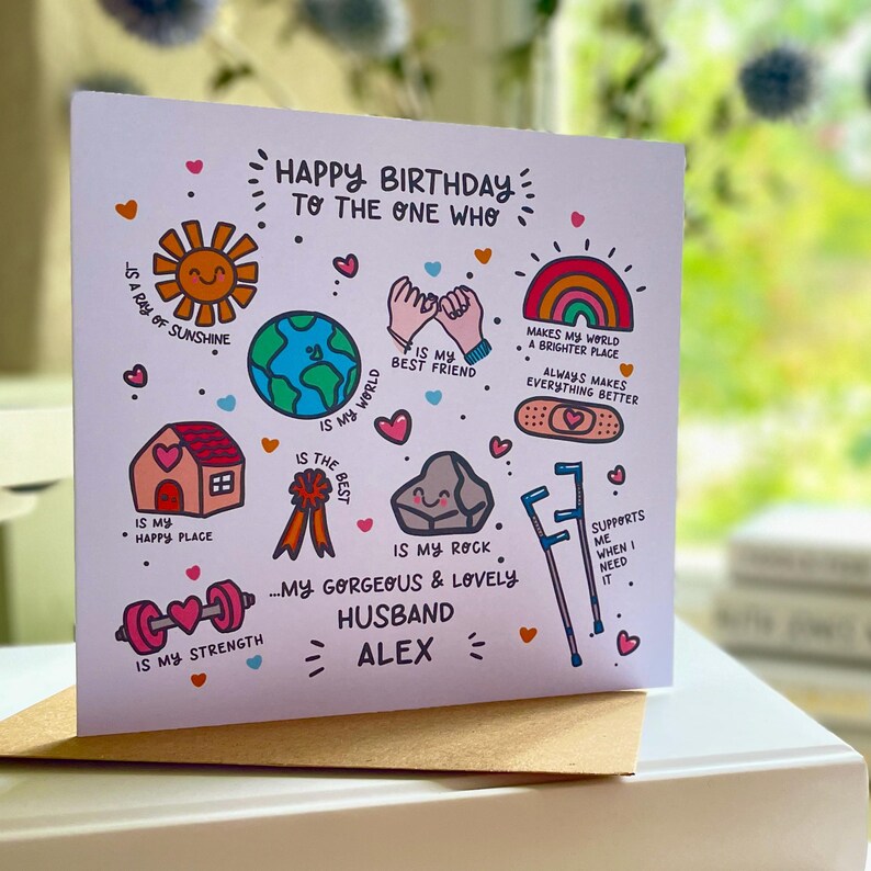 May include: A square greeting card with a white background featuring colorful hand-drawn illustrations and text. Icons include a sun, earth, pinky promise, rainbow, house, ribbon, rock, bandage, crutches, and barbell with text addressing a husband named Alex.